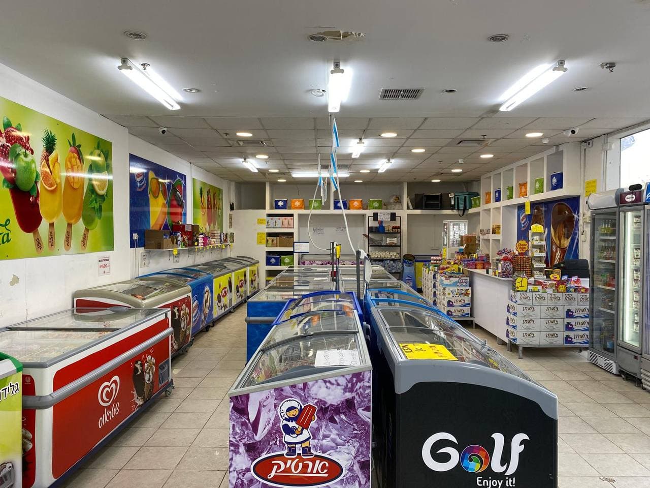 החנות של ריאו בעיר — מקפיאי תצוגה מלאים בגלידות, ארטיקים וקינוחים קפואים מכל המותגים